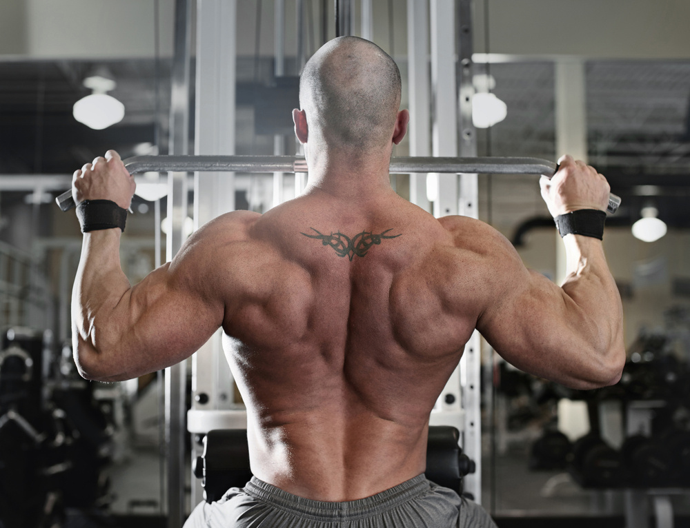 bodybuilder working out at the gym while using fitness machine